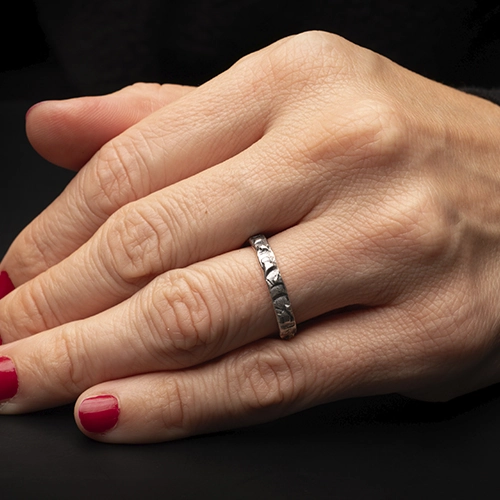 AP00262500-3 Anillo de plata 925 Crisan Unix1 usado en mano con fondo oscuro