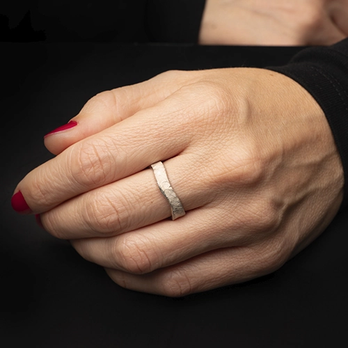 Anillo Crisan Ondu de plata 925 usado en mano sobre fondo negro