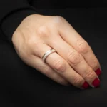 Anillo modelo Dual de plata 925 usado en mano sobre fondo oscuro