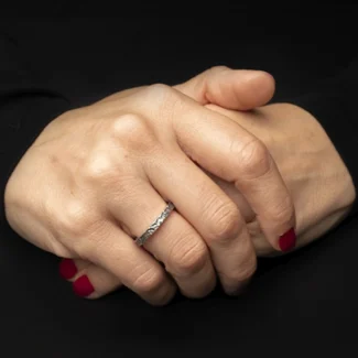 Anillo Mich de plata 925 usado en mano sobre fondo negro