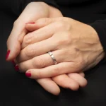 Anillo Mich de plata 925 con detalle dorado usado en mano sobre fondo oscuro