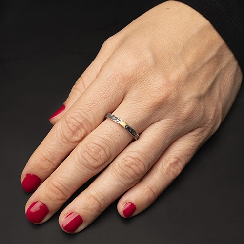 AP02362900-2- Anillo Yunc de plata 925 con detalle dorado usado en mano sobre fondo oscuro