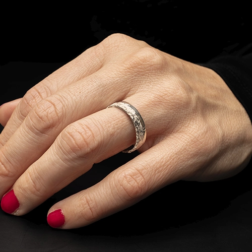 Anillo Mocn de plata 925 usado en mano sobre fondo oscuro