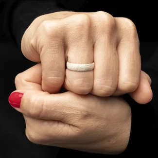 Anillo Crisan Textu de plata en mano femenina sobre fondo oscuro